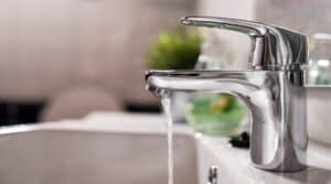 Cold water flowing from faucet in clean bathroom
